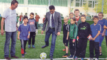 Die Startformationen der beiden Mannschaften für das erste Spiel schauen mit Schulleiter Alfred Scholemann (1.) interessiert, ob denn der „Herr Bürgermeister“ (M.) auch ordentlich den ersten Anstoß ausführt. Foto: Müller